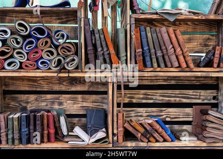 vista orizzontale di taccuini fatti a mano con rivestimento in pelle su scaffali da libro realizzati con scatole in legno. pelletteria con materiali riciclati Foto Stock