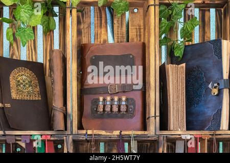 vista orizzontale di taccuini fatti a mano con rivestimento in pelle su scaffali da libro realizzati con scatole in legno. pelletteria con materiali riciclati Foto Stock