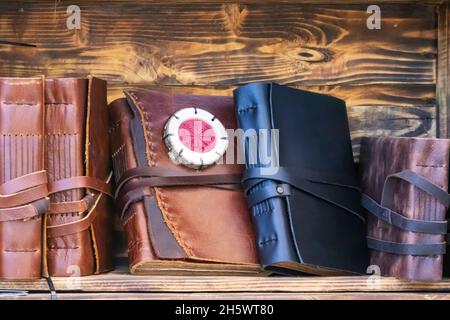 vista orizzontale di taccuini fatti a mano con rivestimento in pelle su scaffali da libro realizzati con scatole in legno. pelletteria con materiali riciclati Foto Stock