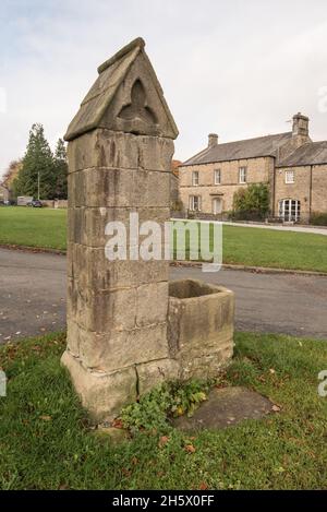 Il centro del villaggio e il monumento che si affaccia sul vasto verde del villaggio di Arncliffe a Littondale, Yorkshire Dales National Park Foto Stock