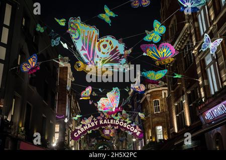 Londra, Regno Unito. 10 novembre 2021. Il Caleidoscopio di Natale Carnaby è raffigurato sopra Carnaby Street nel West End. Le luci di Natale di Carnaby Street di quest'anno, che includono oltre 600 farfalle 3D e 2D decorate a mano, sono state installate in collaborazione con Choose Love per evidenziare l'urgente necessità di raccogliere fondi per i rifugiati in tutto il mondo. Credit: Mark Kerrison/Alamy Live News Foto Stock