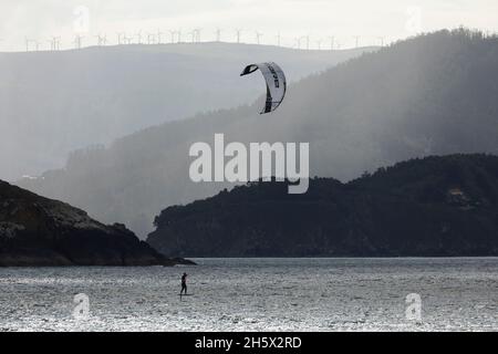 Ortigueira, Spagna - 18 ago 2020: Kitesurfer praticare sport, kiteboarding o kitesurfing, nel Rias Altas, in Galizia, nel mezzo di un beautifu Foto Stock