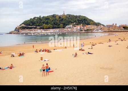 Villeggianti sulla spiaggia presso la località balneare spagnola di San Sebastian nella baia di Biscay Cantabria nel nord della Spagna Foto Stock