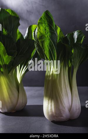 Sano fresco bok choy cavoli foglia vegetale posto su tavola nera su sfondo scuro Foto Stock