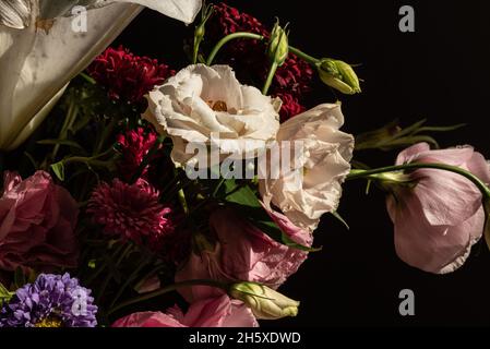 Bouquet di fiori freschi, tra cui l'eustoma di gigli bianchi e l'astro in vaso di vetro al sole Foto Stock