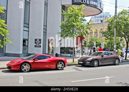 Kiev, Ucraina - 10 giugno 2013: Ferrari 458 Italia e Porsche Panamera in città. Ferrari rossa Foto Stock