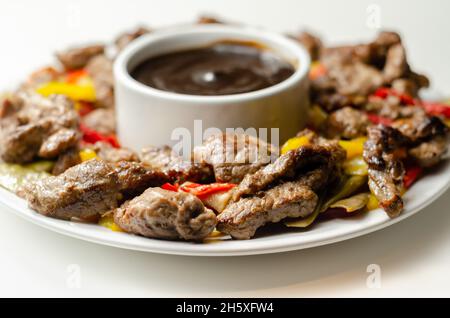 Strisce di manzo con peperoni misti e mangetout serviti con salsa di fagioli neri, pasto cinese Foto Stock