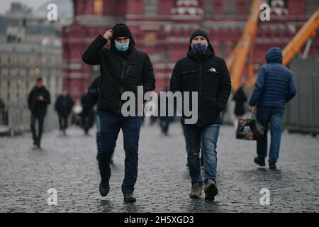 Mosca, Russia. 11 Nov 2021. Le persone che indossano maschere per il viso camminano su una strada a Mosca, in Russia, il 11 novembre 2021. La Russia ha confermato 40,759 infezioni da COVID-19 nelle ultime 24 ore, portando il conteggio nazionale a 8,952,472, il centro ufficiale di monitoraggio e risposta ha detto Giovedi. Credit: Evgeny Sinitsyn/Xinhua/Alamy Live News Foto Stock