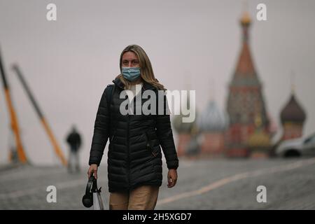 Mosca, Russia. 11 Nov 2021. Una donna che indossa una maschera per il viso cammina su una strada a Mosca, Russia, il 11 novembre 2021. La Russia ha confermato 40,759 infezioni da COVID-19 nelle ultime 24 ore, portando il conteggio nazionale a 8,952,472, il centro ufficiale di monitoraggio e risposta ha detto Giovedi. Credit: Evgeny Sinitsyn/Xinhua/Alamy Live News Foto Stock