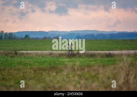 Un motociclista (motociclista) che guida la sua moto lungo una pista di pietra a Salisbury Plain, Wiltshire Foto Stock