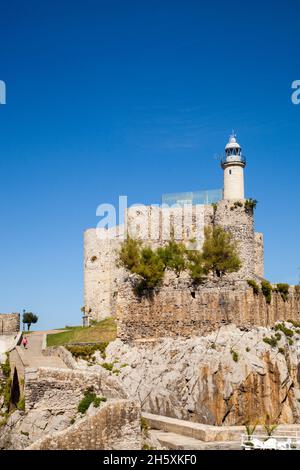 Il castello medievale di Santa Ana oggi ospitava il faro nel porto di pescatori spagnolo e nella località balneare di Castro Urdiales nord della Spagna Foto Stock