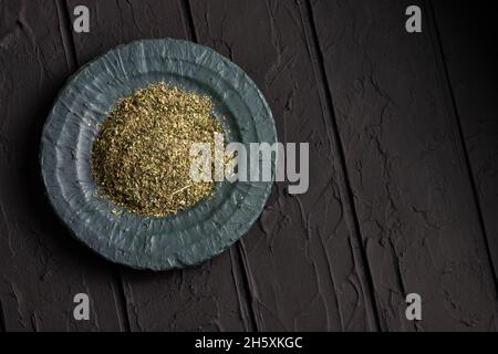 Foglie di dragoncello organico essiccato in ciotola - Artemisia dracunculus Foto Stock