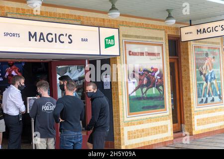 Australia giovani uomini che indossano facemarks durante l'epidemia di covid, check-in al pub Hotel Styeyne a Manly Beach Sydney, Australia Foto Stock