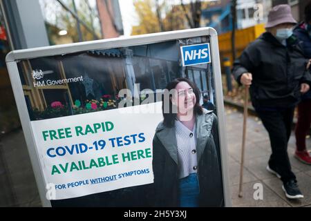 Manchester, Gran Bretagna. 10 novembre 2021. La gente cammina oltre un segno di prove libere rapide COVID-19 a Manchester, Gran Bretagna, 10 novembre 2021. La Gran Bretagna giovedì ha registrato 42,408 nuove infezioni da COVID-19 e 195 decessi correlati al coronavirus, portando la perdita totale di vite a 142,533 nel paese, secondo le ultime cifre ufficiali. Credit: Jon Super/Xinhua/Alamy Live News Foto Stock