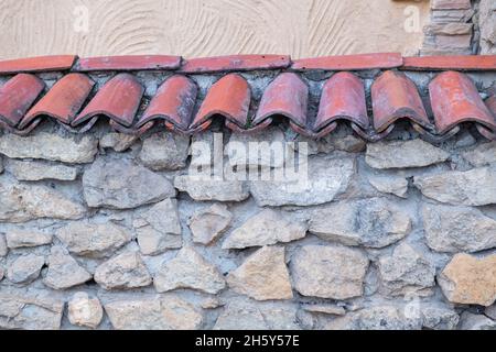 tegole rosse vintage su un muro di pietra Foto Stock