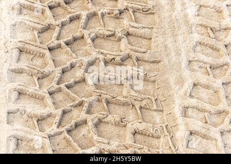 Battistrada di pneumatici in sabbia fresca su una spiaggia oceanica Foto Stock