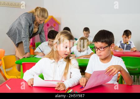 Gli scolari chiacchierano durante la lezione Foto Stock