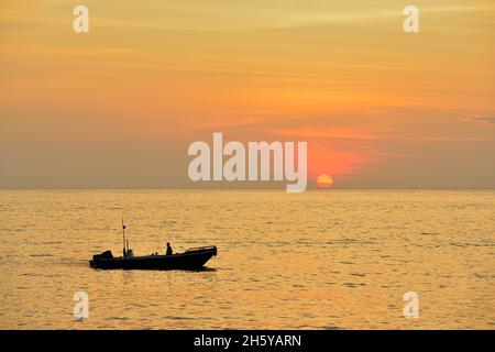 Sunrise e barca da pesca, Parco Nazionale delle Isole Galapagos, Isola di Santa Fe, Ecuador Foto Stock