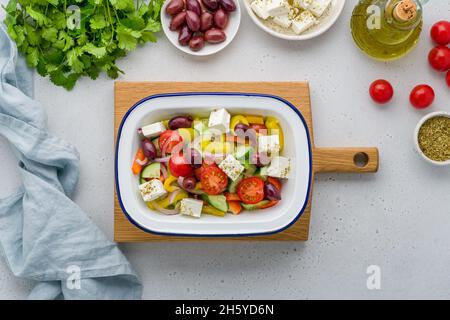 Insalata popolare in cucina greca fatta con pezzi di pomodori, cetrioli, cipolla, formaggio feta, olive e condita con sale, pepe, origano, e oliva o Foto Stock