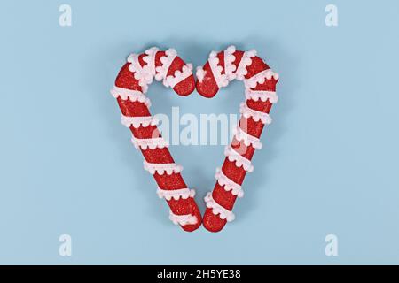 Due ornamenti natalizi di canna di caramella che formano la forma del cuore Foto Stock