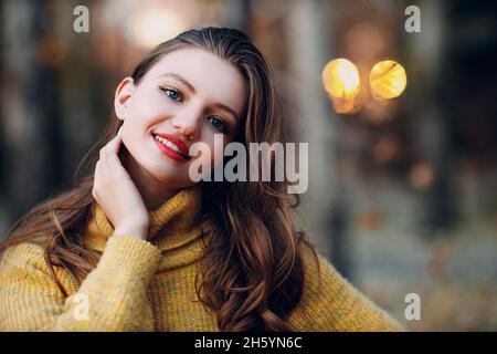 Giovane donna 18 anni modello in autunno parco con foglie di acero giallo fogliame. Moda stagione autunnale Foto Stock