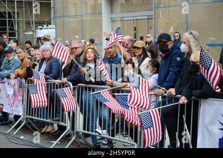 New York, Stati Uniti. 11 Nov 2021. Gli spettatori hanno visto con bandiere americane sul lato della strada durante l'annuale Veterans Day Parade lungo la 5th Avenue a New York City il 11 novembre 2021. (Credit Image: © Ryan Rahman/Pacific Press via ZUMA Press Wire) Credit: ZUMA Press, Inc./Alamy Live News Foto Stock