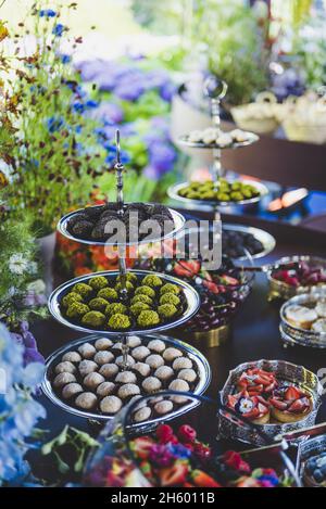 Colpo verticale di un tavolo con vari tipi di dessert con frutta diversa Foto Stock