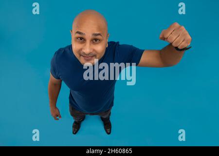 Ritratto di un uomo calvo vicino fisted che mostra un pugno contro sfondo semplice. Foto Stock