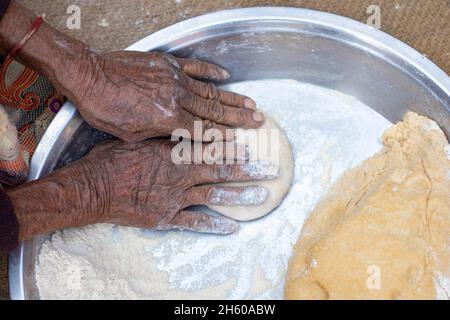 Donna anziana mano facendo chapati. Foto Stock