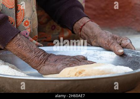 Donna anziana mano che fa roti Foto Stock