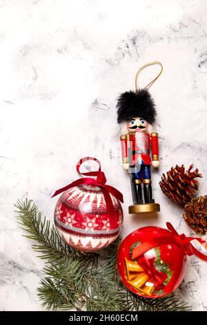 Decorazioni di Natale. nutcracker, palle, coni di pino su sfondo testurizzato. Foto Stock