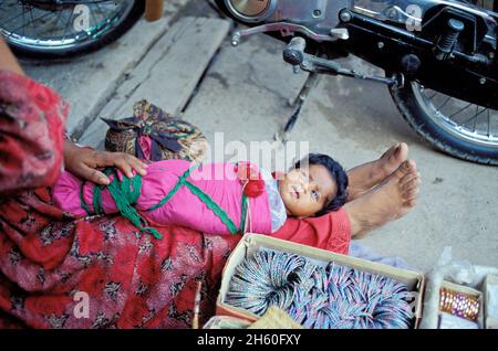 Madre con bambino al mercato di strada, Peshawar, Città Vecchia, Khyber Pakhtunkhwa, Pakistan Foto Stock