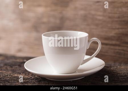 caffè espresso bianco in ceramica o tazzina da tè su sfondo di legno tonalità vintage Foto Stock