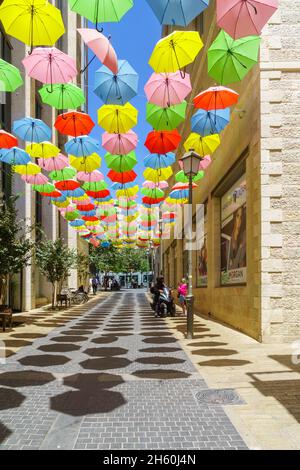 Gerusalemme, Israele - 30 agosto 2021: Pedoni e ombrelloni colorati, in via Yoel Moshe Solomon, lo storico vicino Nachalat Shiva Foto Stock