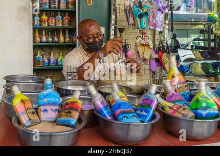 Aqaba, Giordania - 21 ottobre 2021: Scena di strada con un artigiano che prepara bottiglie di vetro con sabbia colorata, in Aqaba, Giordania Foto Stock