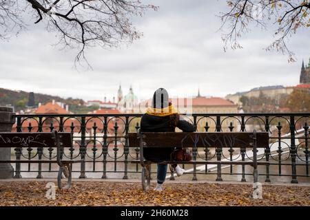 PRAGA, REPUBBLICA CECA - 7 NOVEMBRE 2021 - ragazza nel parco su una panchina di fronte al Danubio. Foto Stock