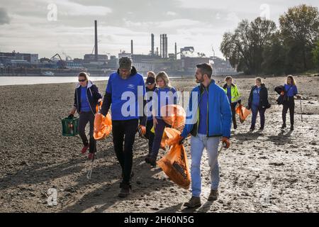 Dotati di pinze e sacchetti riciclabili per rifiuti, volontari dell'organizzazione ambientale KRAKE e.V. raccogliere rifiuti sulla riva sinistra del Reno di fronte al ponte Leverkusen vicino a Colonia, 26 ottobre 2021 -- - ausgestattet mit Greifzangen und recycelbaren Müllsäcken sammeln Freiwillige der Umweltorganisation KRAKE e.V. das linksrheinische Ufer vor der Leverkusener Brücke bei Köln Unrat und Müll. Köln, 26.10.2021 Foto Stock