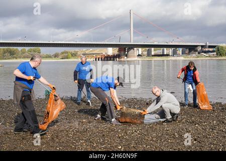 Dotati di pinze e sacchetti riciclabili per rifiuti, volontari dell'organizzazione ambientale KRAKE e.V. raccogliere rifiuti sulla riva sinistra del Reno di fronte al ponte Leverkusen vicino a Colonia, 26 ottobre 2021 -- - ausgestattet mit Greifzangen und recycelbaren Müllsäcken sammeln Freiwillige der Umweltorganisation KRAKE e.V. das linksrheinische Ufer vor der Leverkusener Brücke bei Köln Unrat und Müll. Köln, 26.10.2021 Foto Stock