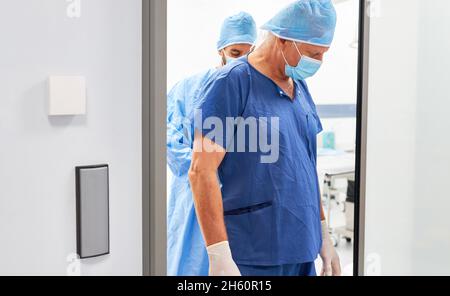 Medico o infermiere esausto con maschera dopo un'operazione di spostamento o di esaurimento Foto Stock