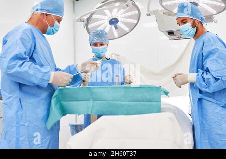 Il medico e il team di chirurgia senior si preparano per un intervento nella sala operatoria della clinica Foto Stock