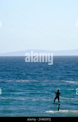 Lone surfer kite surf con aliscafo in acqua al largo di Los Lances Beach.Tarifa, Costa de la Luz, provincia di Cadice, Andalusia, Spagna Foto Stock