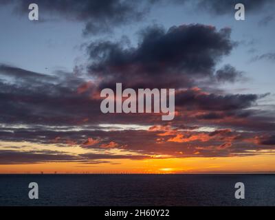 Cielo al tramonto sul canale inglese da Peacehaven nel Sussex orientale, Inghilterra, con nuvole e gabbiano. Foto Stock