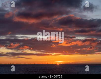 Tramonto sul canale inglese con Rampion Wind Farm all'orizzonte. Foto Stock