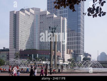 Vista del Bundaran Hotel Indonesia con il monumento Selamat Datang e fontana d'acqua di mattina. Folla di persone in strada durante l'evento auto free. Foto Stock