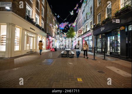 LONDRA - 1 NOVEMBRE 2021: Acquirenti su Carnaby Street con le luci di Natale sullo sfondo Foto Stock