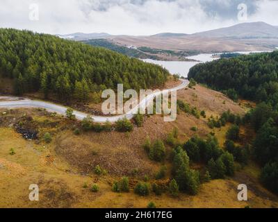 Veduta aerea del paesaggio montano con strada e lago in un bell'ambiente foggiato. Natura all'aperto destinazione di viaggio, Zlatibor, Serbia Foto Stock