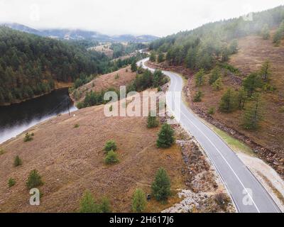 Veduta aerea del paesaggio montano con strada e lago in un bell'ambiente foggiato. Natura all'aperto destinazione di viaggio, Zlatibor, Serbia Foto Stock