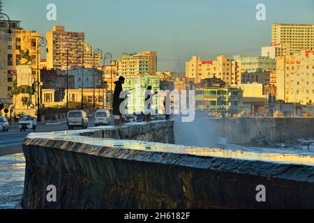 Malecón (ufficialmente Avenida de Maceo) ha fatto da sagome ai pescatori che si trovavano in piedi sul muro di mare la mattina . La Habana (l'Avana), Habana, Cuba Foto Stock