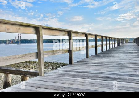 Una lunga banchina di legno si estende verso l'orizzonte. Spazio di copia. Port Jefferson, New York. Foto Stock