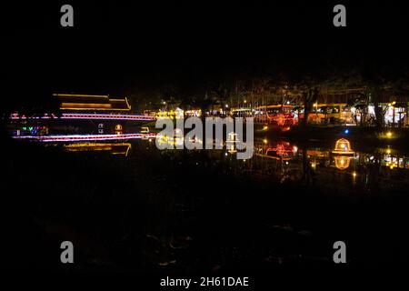 SIEM REAP, CAMBOGIA - 12 agosto 2017: Un ponte che attraversa il fiume Siem Reap decorato con luci colorate e luminose, e lanterne galleggianti sull'acqua, vicino Foto Stock